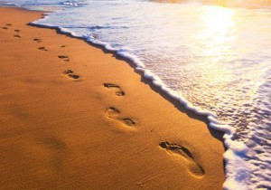 Das Bild zeigt Fußspuren am Strand. Es soll ausdrücken: „Zahnarztangst sollte man in kleinen Schritten besiegen.“